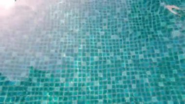 Yüzme havuzu manzaralı. Otelde dinlenmek için mavi su havuzu ve tatil gününde chllin ya da seyahat, spor, eğlence ve üst görüş açısı. POV üst açı görüntüleri yüzme havuzunun dalgalanmasını gösterdi.