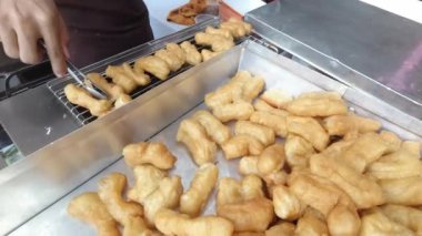 Kızarmış hamur çubuğu barbeküde ızgara yapıyor. Singapur 'da Youtiao adında çok ünlü bir Asya yemeği ya da şefin ızgara yaptığı beyaz şeker süngerli kek. Tayland 'da patongo denir..  