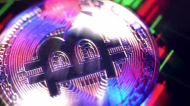 Bitcoin ve borsa grafiği dönüyor. Kripto para birimi Bitcoin yerde dönüyor. Bitcoin 'i pembe mavi ışıkla kapatın. Borsa grafik çubuğu. Kripto para birimi BTC dijital para. sanal varlıklar.