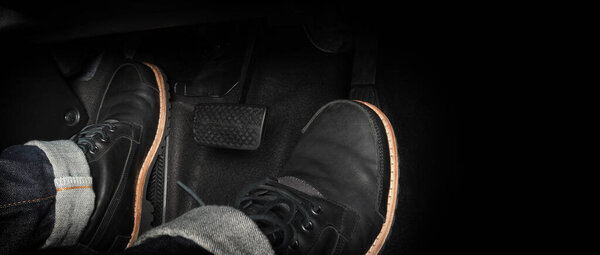 Нога нажимает педаль педали автомобиля для вождения. Ускоритель и тормозная педаль в машине. Водитель за рулем автомобиля нажимает на акселератор и ломает педали автомобиля. Внутри машины. управляющая педаль. Закрыть.
