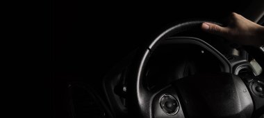 Direksiyon ve erkek eli. Siyah deri modern araba. İç mekan yakın. Araba kullanmak için ellerini direksiyona koy. Dümen kontrolü, korna, silecek ve otomatik vites gibi..