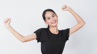 Beyaz arka planda duran Asyalı genç kadın hareketi. Neşeli ve kendinden emin. Mini kalp gibi mimimikler gösteriyor Tamam başparmak yukarı ya da işaret. Mutlu, heyecanlı ve şaşırmış ceket kotları.