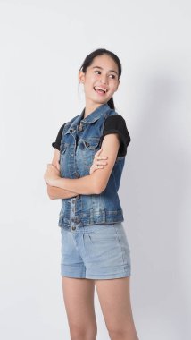 Beyaz arka planda duran Asyalı genç kadın hareketi. Neşeli ve kendinden emin. Mini kalp gibi mimimikler gösteriyor Tamam başparmak yukarı ya da işaret. Mutlu, heyecanlı ve şaşırmış ceket kotları.