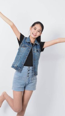 Beyaz arka planda duran Asyalı genç kadın hareketi. Neşeli ve kendinden emin. Mini kalp gibi mimimikler gösteriyor Tamam başparmak yukarı ya da işaret. Mutlu, heyecanlı ve şaşırmış ceket kotları.