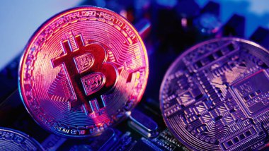 Bitcoin ve yarı iletken. Kripto para birimindeki madencilik küresel ısınmaya neden olur. Bitcoin 'ler işlemci panosunda. Mavi ve pembe ışıklı Bitcoin 'e yakın çekim. Altında para olan devre kartı. Çevrimiçi varlık kavramı. 