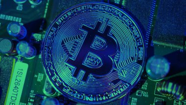 Bitcoin ve yarı iletken. Kripto para birimindeki madencilik küresel ısınmaya neden olur. Bitcoin 'ler işlemci panosunda. Mavi ve pembe ışıklı Bitcoin 'e yakın çekim. Altında para olan devre kartı. Çevrimiçi varlık kavramı. 