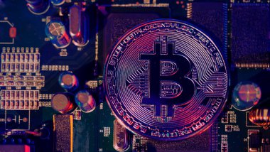 Bitcoin ve yarı iletken. Kripto para birimindeki madencilik küresel ısınmaya neden olur. Bitcoin 'ler işlemci panosunda. Mavi ve pembe ışıklı Bitcoin 'e yakın çekim. Altında para olan devre kartı. Çevrimiçi varlık kavramı. 
