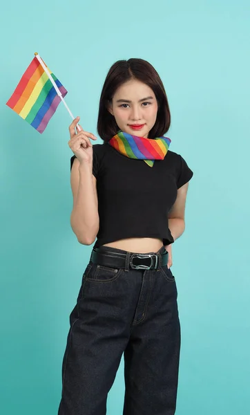 Lgbtqの女の子と誇りの旗 セクシーなレズビアンの女の子とLgbtqの旗が立っています 青緑の背景 首に虹色のスカーフを持つアジアのLgbtqの女性 元気がいいわね Lgbtqの概念 Lgbtqa プライド月間 — ストック写真