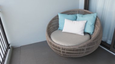 Otel odasındaki balkonda ya da terasta Rattan ve kahverengi renkli yuvarlak şekilli doğal ahşaptan yapılmış plaj sandalyesi. Rahatlamak ya da uyumak ya da parti yapmak için lüks görünüyor..