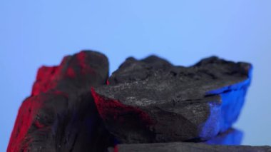 Kömür kömürü. Doğal ahşap ya da geleneksel siyah kömür döngüsü. Renkli LED ışığı olan mavi ya da yeşil ekran arkaplanı. Parazitle çekilmiş. Barbekü ızgarası için kömür. Siyah kömür.