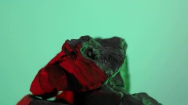 Kömür kömürü. Doğal ahşap ya da geleneksel siyah kömür döngüsü. Renkli LED ışığı olan mavi ya da yeşil ekran arkaplanı. Parazitle çekilmiş. Barbekü ızgarası için kömür. Siyah kömür.