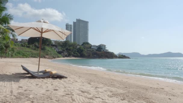 Pattaya Beach. Resort Tagesbetten und Couchtisch mit Sonnenschirm am Strand. Meer winkt mit blauem Himmel Sommer. leichter Wind am Strand von Pattaya Thailand. Keine Menschen bei Covid 19 oder Coronavirus-Pandemie.