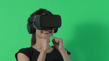VR oyunu oynuyor. Sanal gerçeklik oyunu oynayan Asyalı genç bir kadın. Krom anahtar için mavi ya da yeşil ekran arka planı. Mutluluk ve heyecanla oyun oynuyorlar. Sanal Oyun Dünyası. 