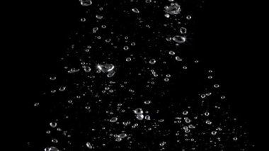 Soda su kabarcıkları su altında ve yüzen su damlaları siyah arka planda. Sinema filmi. Gazoz ve kola gibi gazlı ve ferahlatıcı karbonat içeceklerini temsil eder. Kabarcıklar makro.