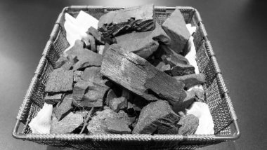 Siyah desenli zeminde siyah kömür. kömür siyah karbon reesidue güçlü ısıtmalı ahşap tarafından üretilir. Yemek pişirmek ya da diğer endüstrilerde kullanılır. Doğal odun kömürü. Geleneksel sert odun kömürü.