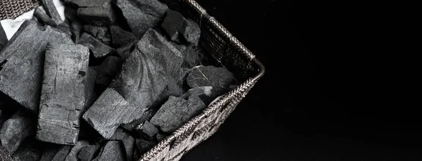 Black Charcoal on black textured floor. charcoal black carbon reesidue produced by strongly heating wood. Used for cooking or other industries. Natural wood charcoal. traditional hard wood charcoal.