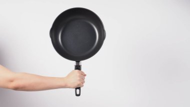 Tencere temizliği. Erkek adam beyaz arka planda, bulaşık deterjanıyla tencereyi temizlerken yumuşak tarafı sarı, yemek pişirdikten sonra hijyen için sert tarafı yeşil. Elektrik tavası. 