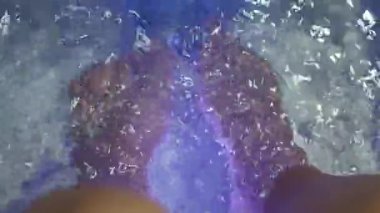 Ayak Spa 'sı. Kaplıcadaki sabun su makinesinde çıplak ayakla masaj yapan bir kadın. Sıcak suda ayak banyosuna giren kadınların ayakları. Kaplıca salonundaki yağ ile ayak masajı. Cilt bakımı.