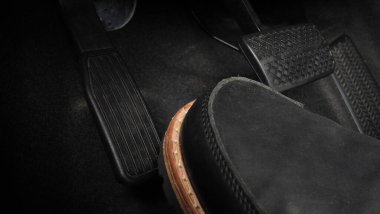 Adam ayağı, gaz pedalı ve arabanın içinde fren pedalı ve hangi siyah deri ayakkabının üzerine bastığını kopyala. Otomobil hızını artırmak veya kontrol etmek için. Otomobil Sürücüsü kavramı