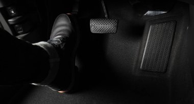 Adam ayağı, gaz pedalı ve arabanın içinde fren pedalı ve hangi siyah deri ayakkabının üzerine bastığını kopyala. Otomobil hızını artırmak veya kontrol etmek için. Otomobil Sürücüsü kavramı