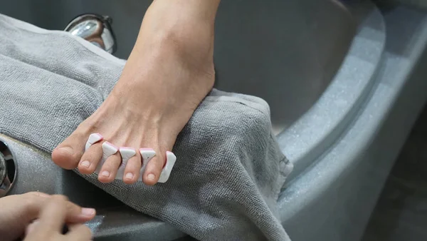 Foot Spa. Woman bare feet massaging in soap water machine at spa shop. Feet of women entering the footbath in the hot water handheld