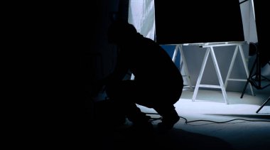 Kamera arkasında video prodüksiyonu. Film ekibinin Lightman ve kameramanın film yönetmeniyle birlikte çalıştığı bir reklam filmi. Film yapım konsepti. Siluet biçimi.