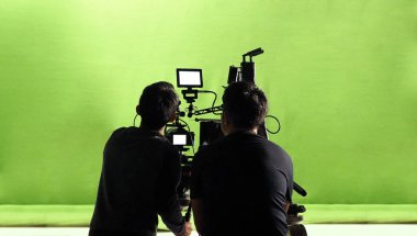Kamera arkasında video prodüksiyonu. Film ekibinin Lightman ve kameramanın film yönetmeniyle birlikte çalıştığı bir reklam filmi. Film yapım konsepti. Siluet biçimi.
