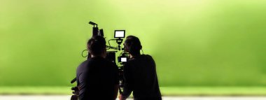 Kamera arkasında video prodüksiyonu. Film ekibinin Lightman ve kameramanın film yönetmeniyle birlikte çalıştığı bir reklam filmi. Film yapım konsepti. Siluet biçimi.