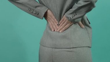 Sırt ağrısı. Sırtından yaralanmış bir iş kadını. Kadın işten sonra sırt ağrısı çekiyor. Ofis sendromu kas iltihabı konsepti. Sırtı ağrıyan bir iş kadını. Sırt ağrısından muzdarip. Yakın çekim görüntüleri..