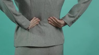 Sırt ağrısı. Sırtından yaralanmış bir iş kadını. Kadın işten sonra sırt ağrısı çekiyor. Ofis sendromu kas iltihabı konsepti. Sırtı ağrıyan bir iş kadını. Sırt ağrısından muzdarip. Yakın çekim görüntüleri..