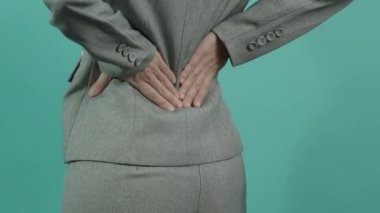 Sırt ağrısı. Sırtından yaralanmış bir iş kadını. Kadın işten sonra sırt ağrısı çekiyor. Ofis sendromu kas iltihabı konsepti. Sırtı ağrıyan bir iş kadını. Sırt ağrısından muzdarip. Yakın çekim görüntüleri..