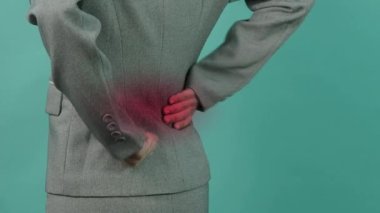 Sırt ağrısı. Sırtından yaralanmış bir iş kadını. Kadın işten sonra sırt ağrısı çekiyor. Ofis sendromu kas iltihabı konsepti. Sırtı ağrıyan bir iş kadını. Sırt ağrısından muzdarip. Yakın çekim görüntüleri..