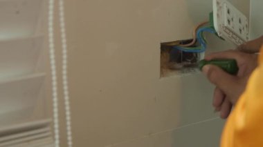 Profesyonel bir elektrikçinin elektrik prizi tamiri ve uzatma kabloları. Matkaplar, kablolar, sigortalar, yüzen kutular ve kablolar gibi ekipmanlarla. Duvar anahtarları ve soketleri yükleniyor.