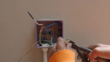Profesyonel bir elektrikçinin elektrik prizi tamiri ve uzatma kabloları. Matkaplar, kablolar, sigortalar, yüzen kutular ve kablolar gibi ekipmanlarla. Duvar anahtarları ve soketleri yükleniyor.