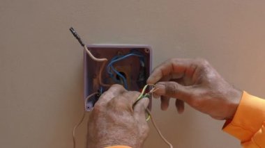 Profesyonel bir elektrikçinin elektrik prizi tamiri ve uzatma kabloları. Matkaplar, kablolar, sigortalar, yüzen kutular ve kablolar gibi ekipmanlarla. Duvar anahtarları ve soketleri yükleniyor.