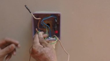 Profesyonel bir elektrikçinin elektrik prizi tamiri ve uzatma kabloları. Matkaplar, kablolar, sigortalar, yüzen kutular ve kablolar gibi ekipmanlarla. Duvar anahtarları ve soketleri yükleniyor.