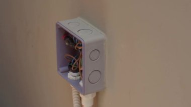 Profesyonel bir elektrikçinin elektrik prizi tamiri ve uzatma kabloları. Matkaplar, kablolar, sigortalar, yüzen kutular ve kablolar gibi ekipmanlarla. Duvar anahtarları ve soketleri yükleniyor.