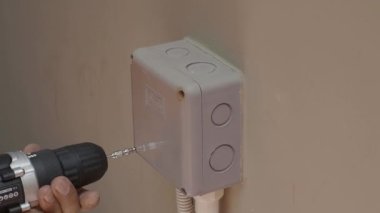 Profesyonel bir elektrikçinin elektrik prizi tamiri ve uzatma kabloları. Matkaplar, kablolar, sigortalar, yüzen kutular ve kablolar gibi ekipmanlarla. Duvar anahtarları ve soketleri yükleniyor.