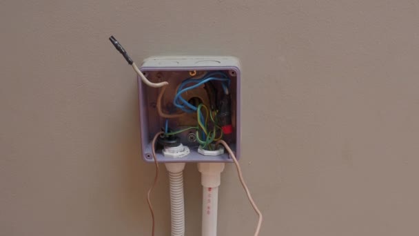 プロの電気技師による電気プラグの修理や拡張コード ドリル ワイヤ ヒューズ フローティングボックス コンジット配線などの機器で構成されています 壁スイッチやソケットの設置 — ストック動画