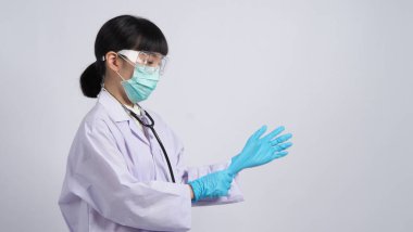 Eldiven takıyordu. Asyalı doktor mavi kauçuk nitril eldiven giyer. Maskeli doktor eldiven takıyor. izole edilmiş beyaz arkaplan kopyalama alanı. Sağlık koruma koronovirüs salgını konsepti.