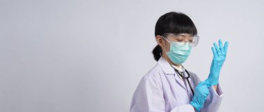 Eldiven takıyordu. Asyalı doktor mavi kauçuk nitril eldiven giyer. Maskeli doktor eldiven takıyor. izole edilmiş beyaz arkaplan kopyalama alanı. Sağlık koruma koronovirüs salgını konsepti.