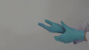 Eldiven takıyordu. Erkek doktor mavi kauçuk nitril eldiven giyer. Doktorun eldiven taktığı görüntüler. izole edilmiş beyaz arkaplan kopyalama alanı. Sağlık koruma koronovirüs salgını konsepti.