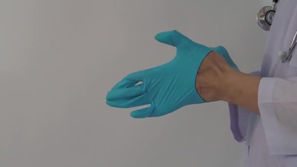 手袋をしてる 男性医師は青ゴムニトリル手手袋を着用してください ドクの手袋をはめた映像 隔離された白い背景コピースペース 医療保護コロナウイルスパンデミックの概念 — ストック動画