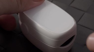 Oksimetre kullanımı. Nabız oksimetresi, nabız ve oksijen seviyelerini ölçmek için kullanılır. Covid 19 salgını sırasında evde bakım. Sağlık hizmeti izleme konsepti. Taşınabilir parmak ucu nabız oksimetresi kullanıyor. 4k