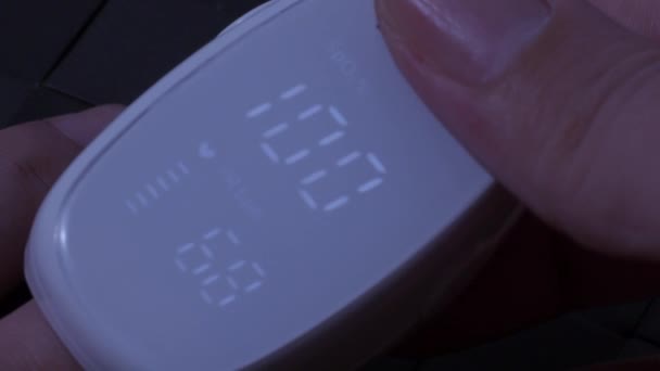 最大使用量 指パルス酸素濃度計は パルス速度と酸素濃度を測定するために使用されます Covid 19パンデミックの間のホームセルフケア 医療監視の概念 携帯型指先パルス酸素濃度計を使っています — ストック動画