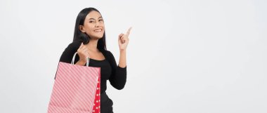 Kadın alışveriş konsepti. Satış sezonunda mutlu bir kız ve alışveriş torbaları. Mutlu Asyalı genç Taylandlı kadın iş başında ya da mağazalardan ya da çevrimiçi dükkanlardan mal satın alıyor ve beyaz bir geçmişi var..