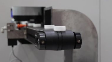 Yüksek hızlı otomatikleştirilmiş üretim hattı. Plastik kapakları hassas robotlarla ayırıp transfer ediyorlar. Kapalı çekimler etkili makine taşıma sistemlerini ve endüstriyel otomasyon fabrikasını gösteriyor..