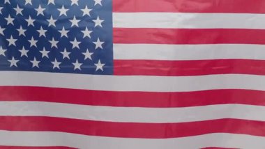 Birleşik Devletler bayrağının yakınında rüzgarda hafifçe sallanıyor. İkonik yıldızlar ve çizgiler özgürlük vatanseverliğini simgeliyor. ABD bayrağı politik tarihi ya da vatansever görseller. Bağımsızlık Günü.