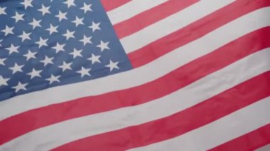 Birleşik Devletler bayrağının yakınında rüzgarda hafifçe sallanıyor. İkonik yıldızlar ve çizgiler özgürlük vatanseverliğini simgeliyor. ABD bayrağı politik tarihi ya da vatansever görseller. Bağımsızlık Günü.