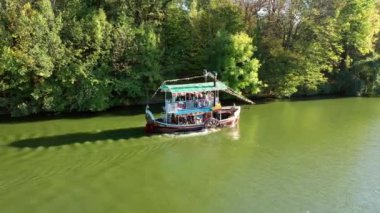 Autumn, bir eğlence gemisi turistleri gölde dolaştırıyor. Sofievsky Parkı, Uman, Ukrayna. Port, mavi.
